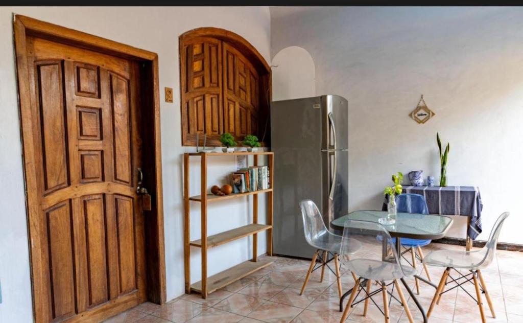 a dining room with a table and a refrigerator at POSADA CENTRO MAZUNTE RINCONCITo in Mazunte