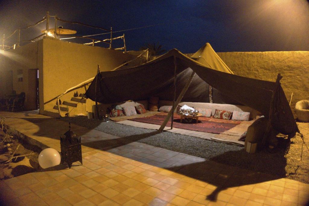 a tent in the middle of a building at night at Tarmguist in Tighmert