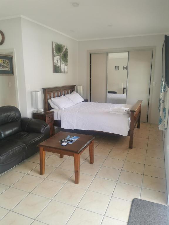 a bedroom with a bed and a couch and a table at Reefton in Reefton