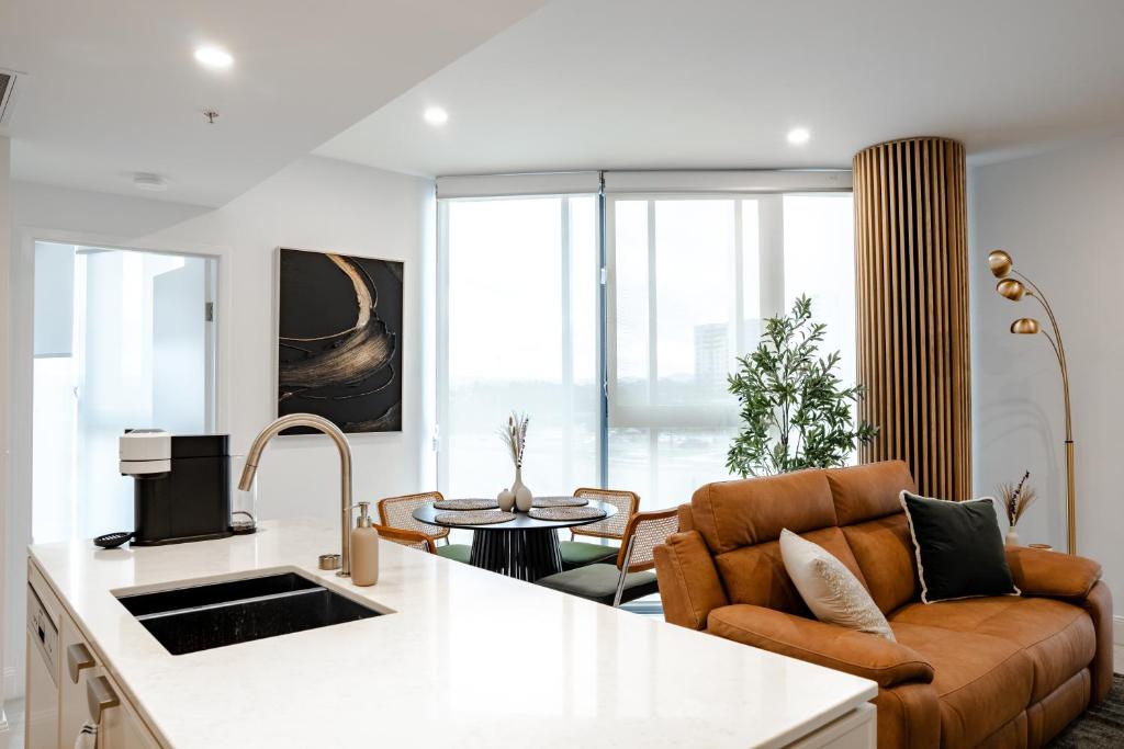 a kitchen and living room with a couch and a table at Chada by Cadiz Properties - 2 Bedroom Apartment with Lakeview Pool, within CBD and Beside Commonwealth Park in Canberra