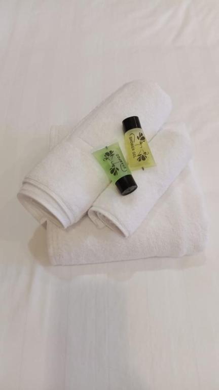 two white towels with tags on them on a bed at BB Hotel in Gerik