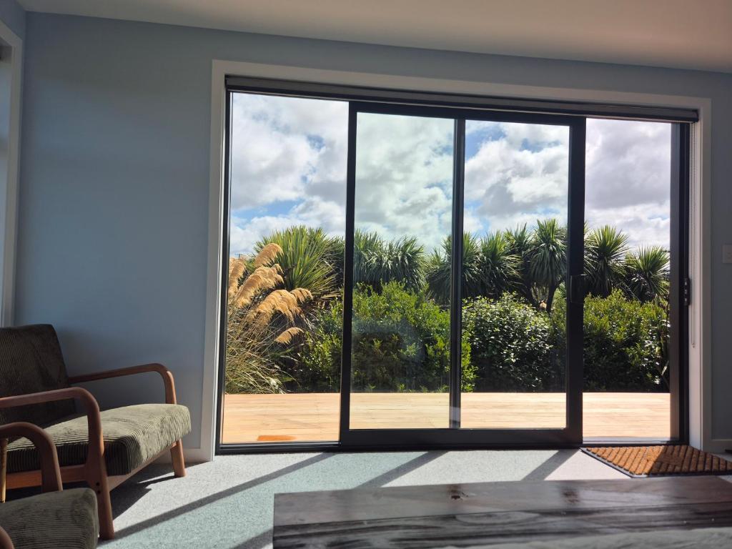 a living room with a large sliding glass door at Accomodation at Curio in Curio Bay