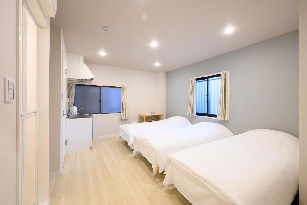 a bedroom with two beds and a flat screen tv at Kohoku Apartment in Tokyo