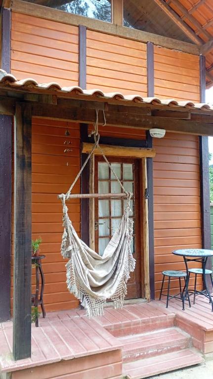 a hammock hanging from the side of a house at Cabana Jandaia in Teresópolis