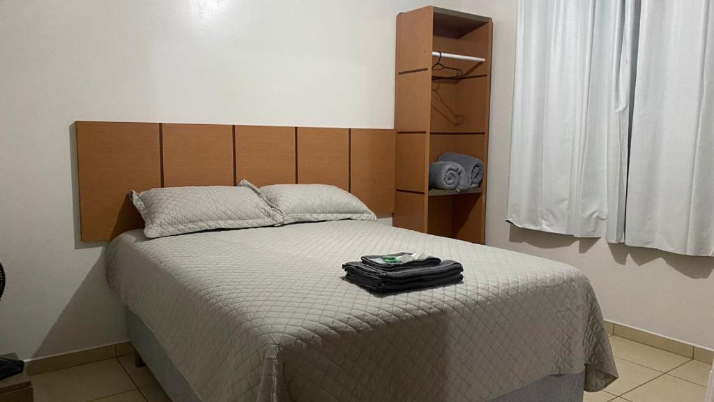 a bedroom with a large bed with a white blanket at Estadia Do Vale Hospedaria União da Vitória in União da Vitória