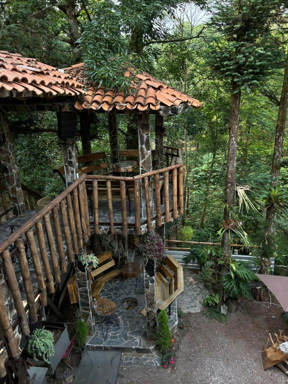 a wooden deck with a gazebo in a garden at Casa Machtiani in Cedro