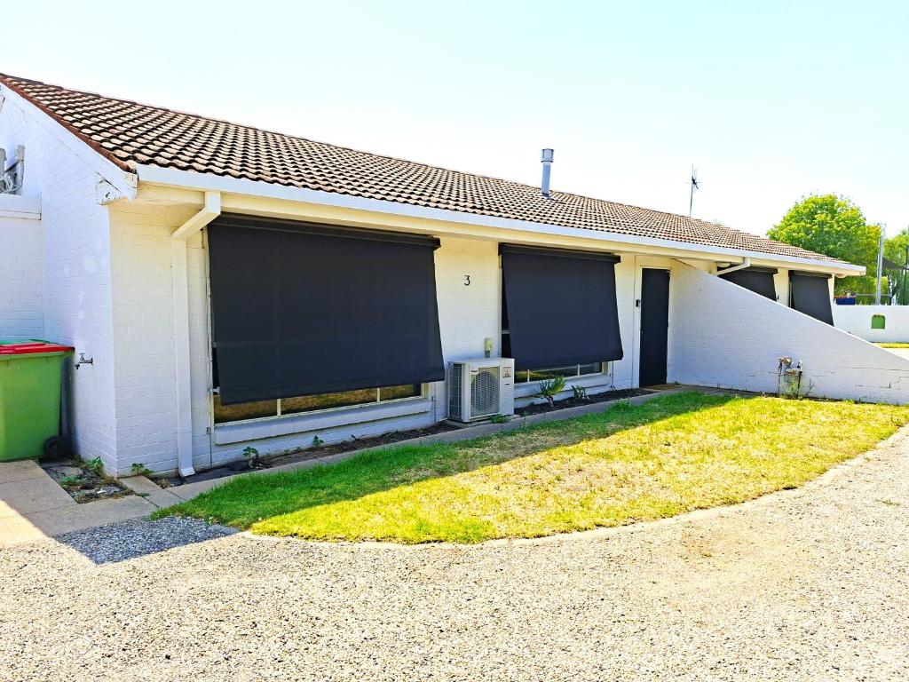 a white house with two roller shades on the side of it at No 3 Lakeside in Mulwala