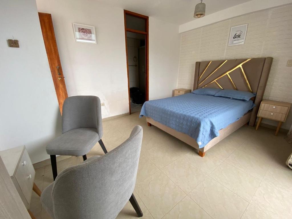 a bedroom with a bed and a chair at Aura house in Huanchaco