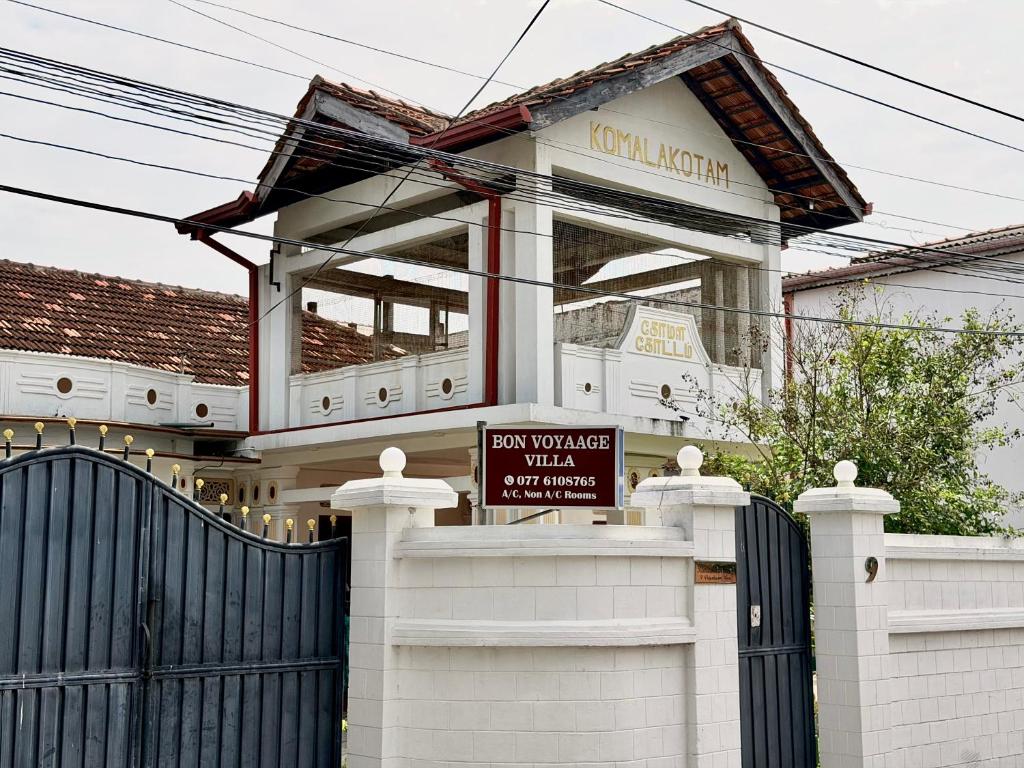 a house with a sign in front of a fence at Bon Voyaage Villa in Trincomalee