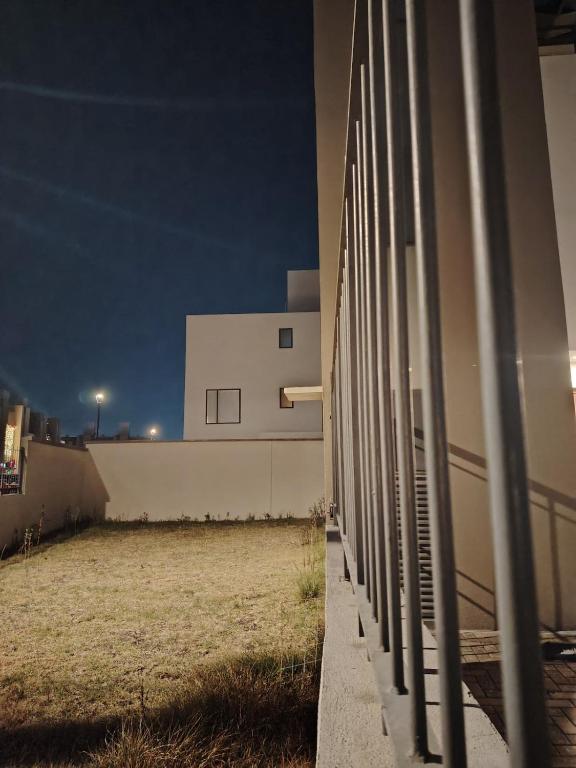 a fence next to a building at night at Amplia casa equipada para familia, pareja o individual in Tizayuca