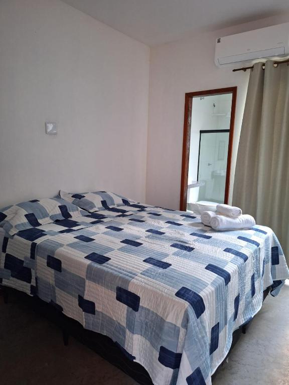 a blue and white bed in a room with a window at Suíte Recanto dos poetas 07 in Lençóis