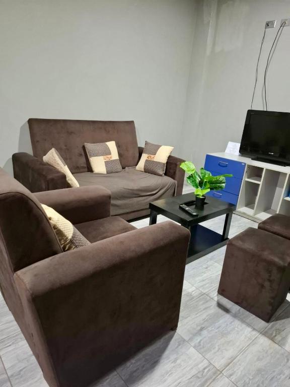 a living room with two couches and a tv at Lily's Apartamentos in Cochabamba