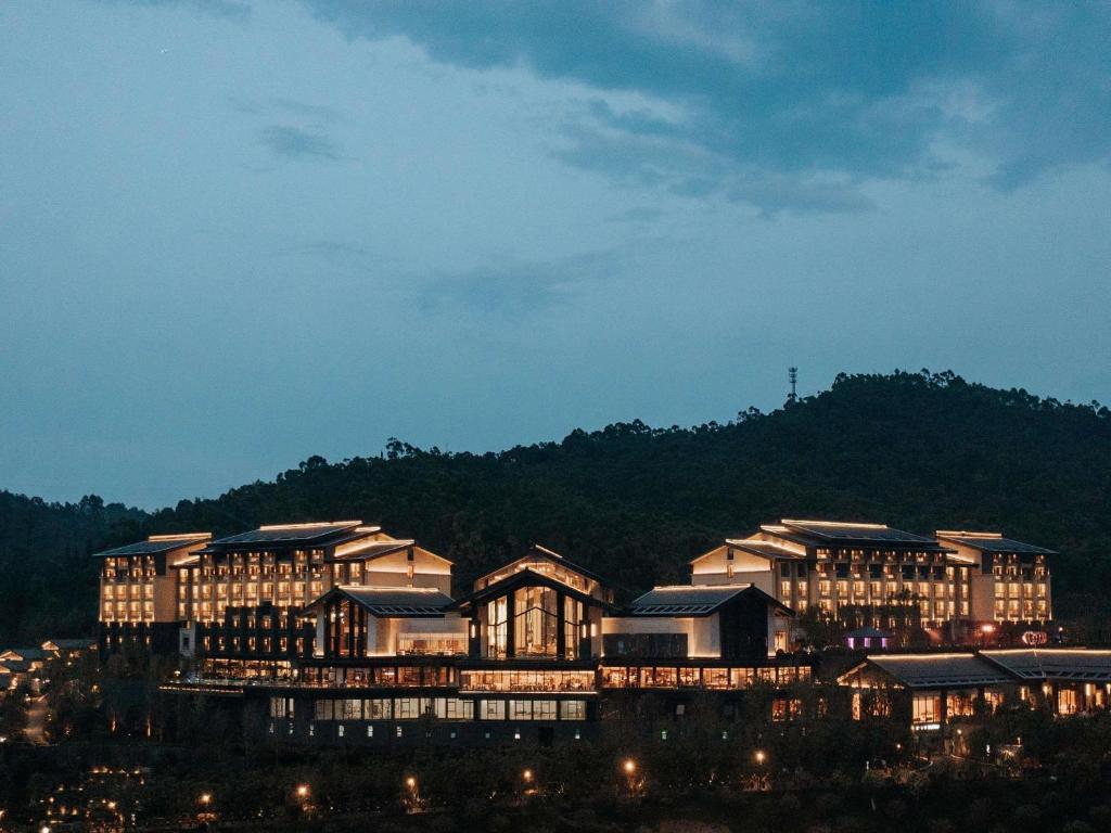 a large building is lit up at night at Pullman Yuxi in Yuxi