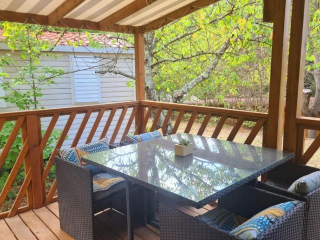 a screened porch with a glass table and chairs at Mobil-home 4 pers avec terrasse - API-1-52-1663 in Espira-de-Conflent