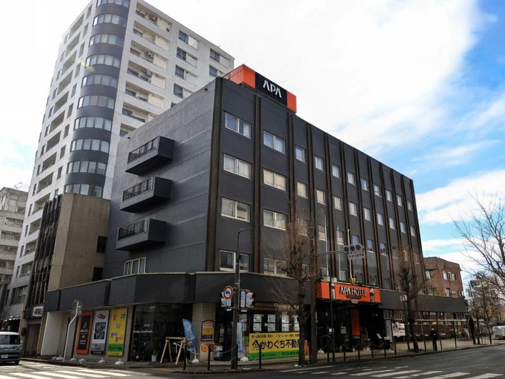 a black building with a sign on top of it at APA HOTEL Fukushima Ekihigasi in Fukushima