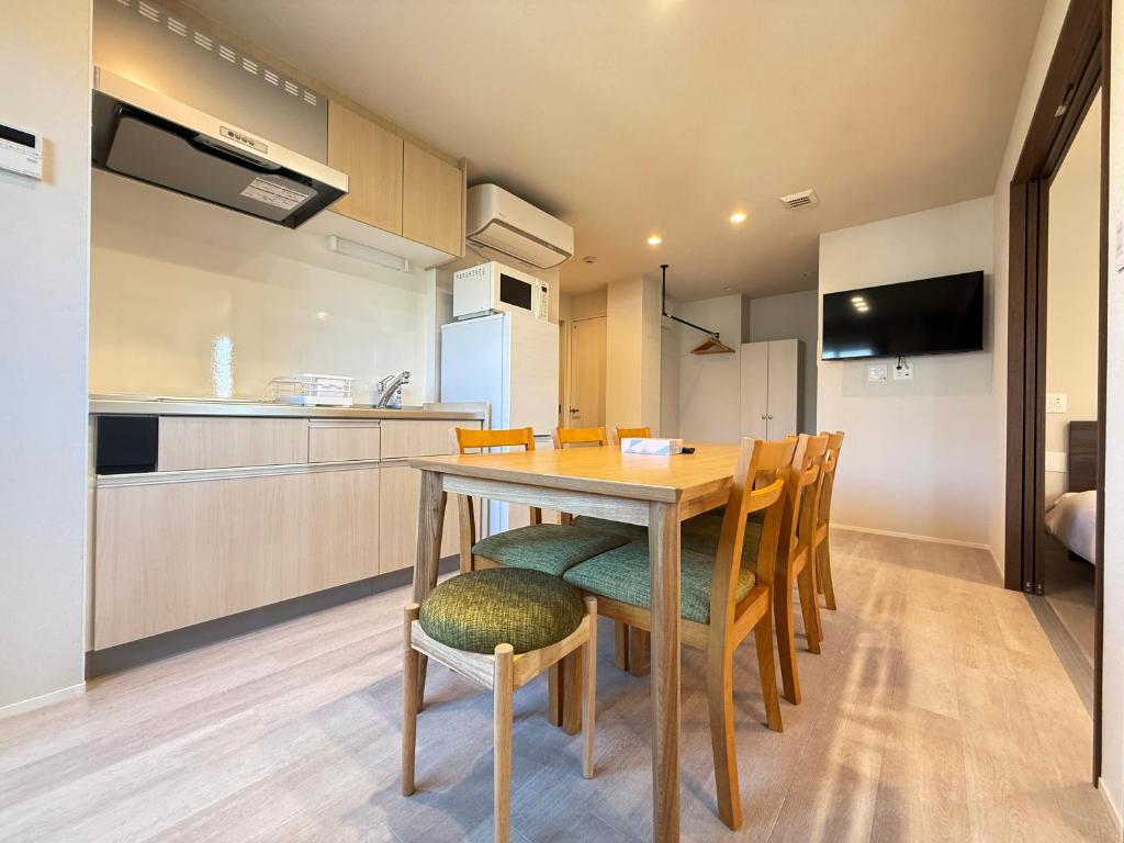 a kitchen and dining room with a wooden table and chairs at PRISM Inn Ikegami Kamata in Tokyo