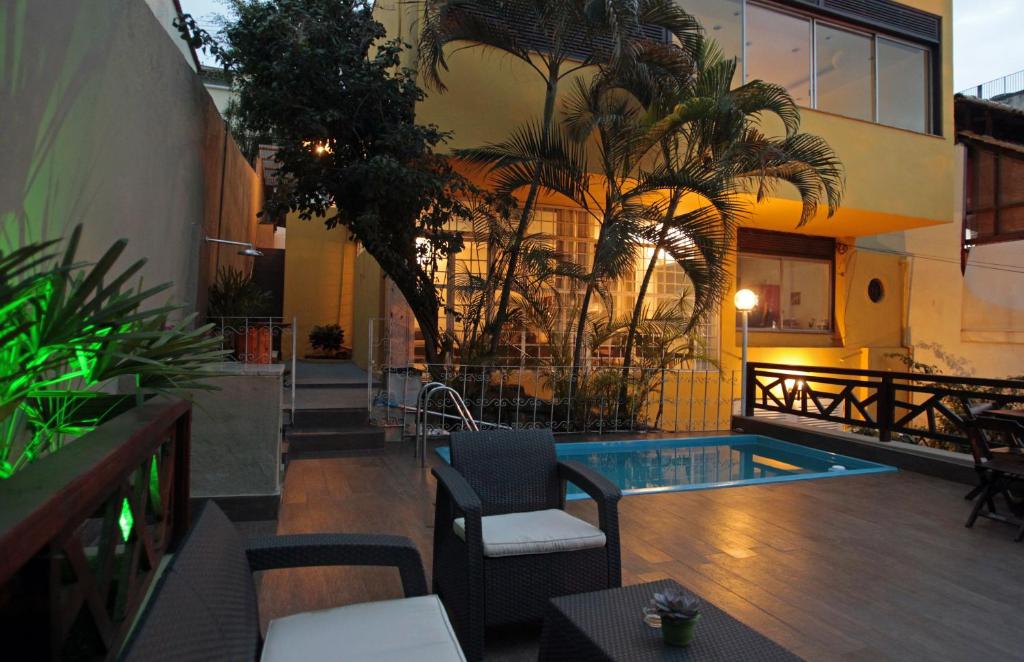 een hotelpatio met een zwembad en palmbomen bij Hangar Rio Hostel in Rio de Janeiro