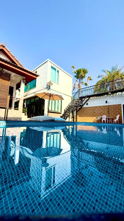 a swimming pool in front of a house at Virawan pool kohlarn วิราวัน พูล รีสอร์ท ที่พักเกาะล้าน in Ko Larn