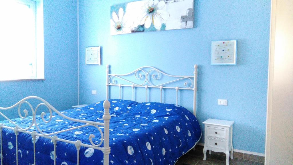 a blue bedroom with a bed with a blue wall at Domus Bolsena in Bolsena