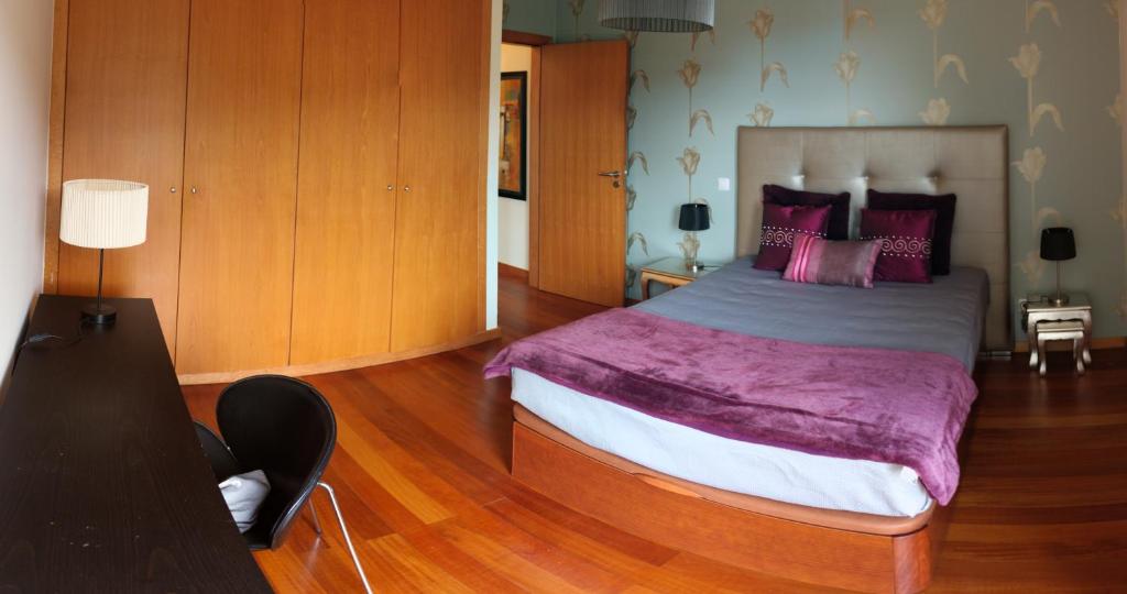 カニコにあるGarajau Cliffのベッドルーム(紫の毛布を使用した大型ベッド1台付)