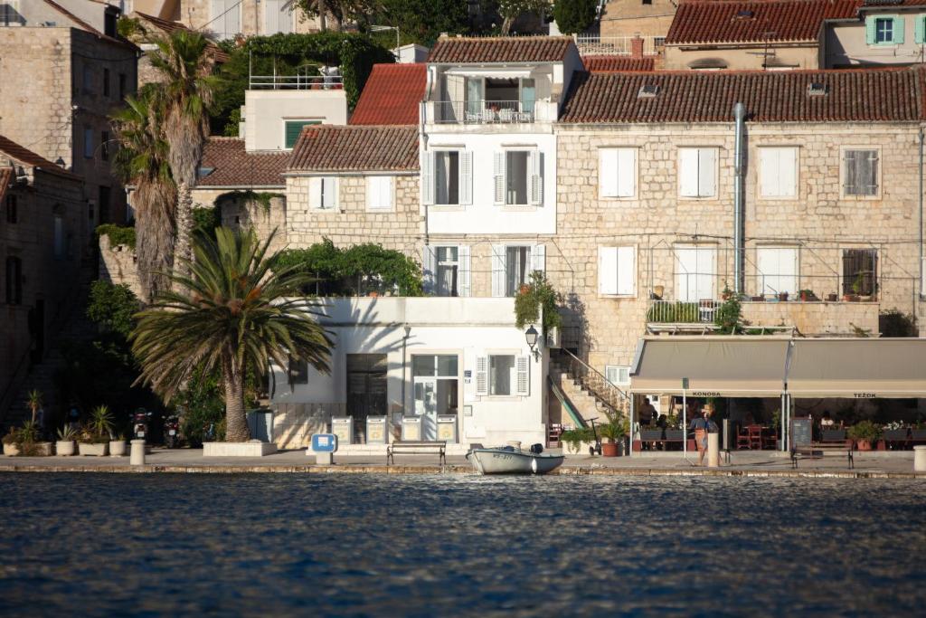 ein Gebäude mit einem Boot auf dem Wasser davor in der Unterkunft Villa Riva, Vis in Vis