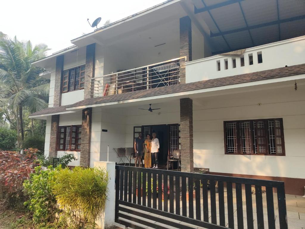 two people standing in the doorway of a house at Pratheeksha Homestay in Kannur