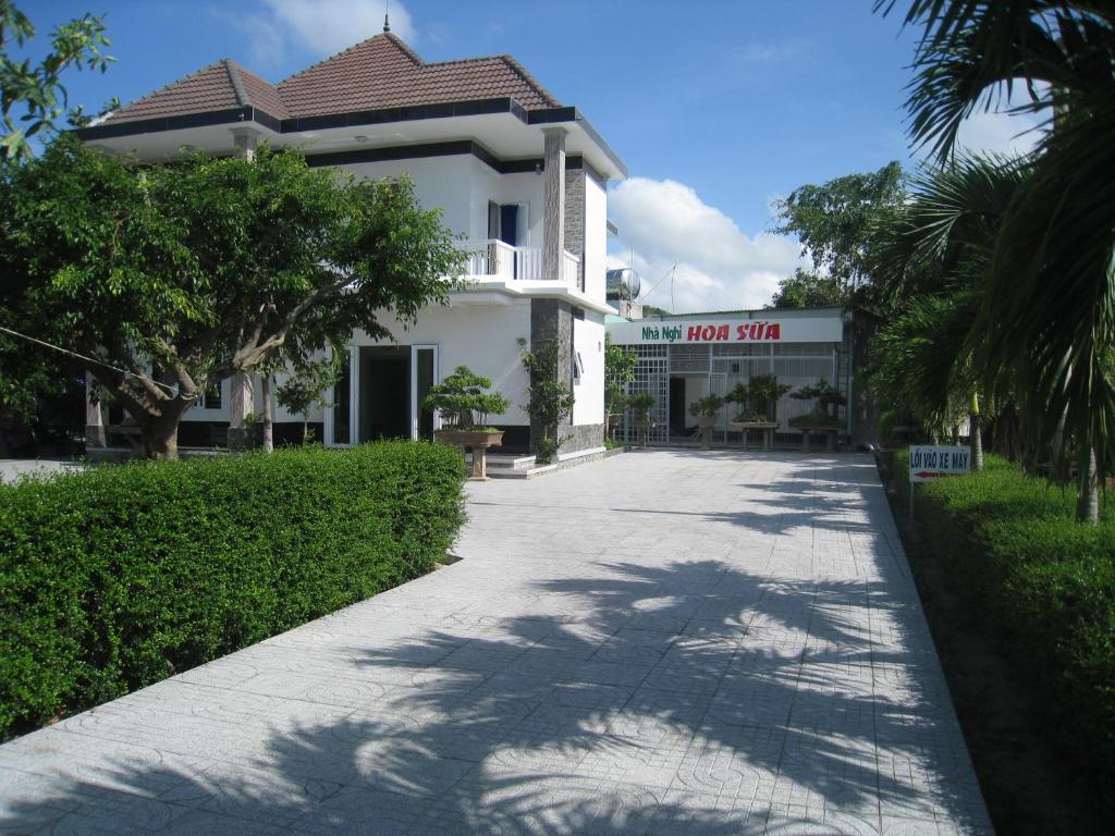 un edificio blanco con un cartel que lee la tienda de la piscina en Hoa Sua Motel, en Long Hai