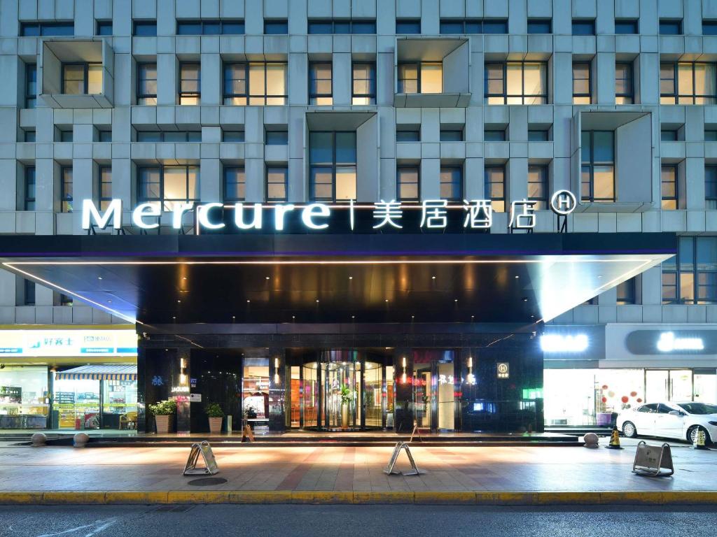 a large building with a sign that reads metrification at Mercure Qidong Downtown in Qidong