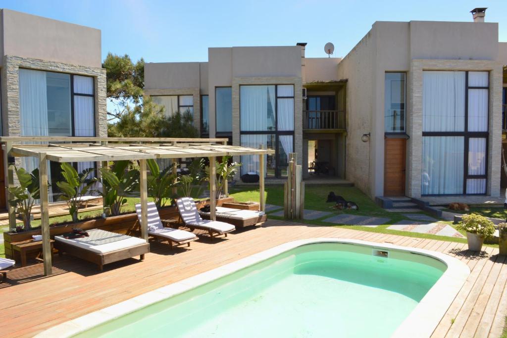 a villa with a swimming pool and a house at Calas del Diablo in Punta Del Diablo