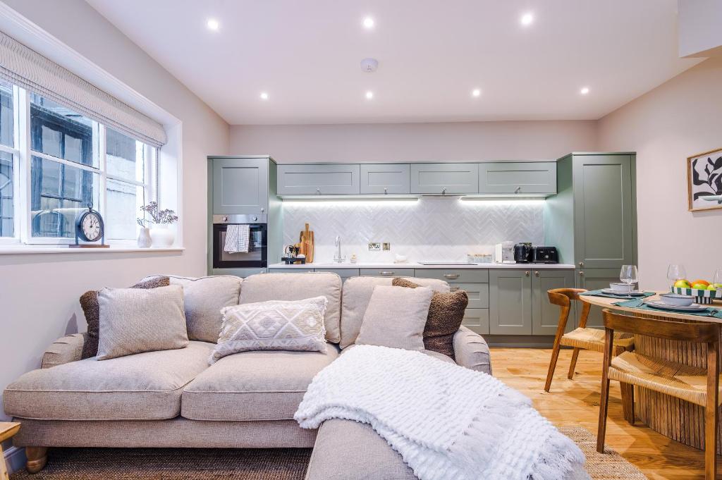 a living room with a couch and a kitchen at Cathedral Mews - Close to the Cathedral in Ripon