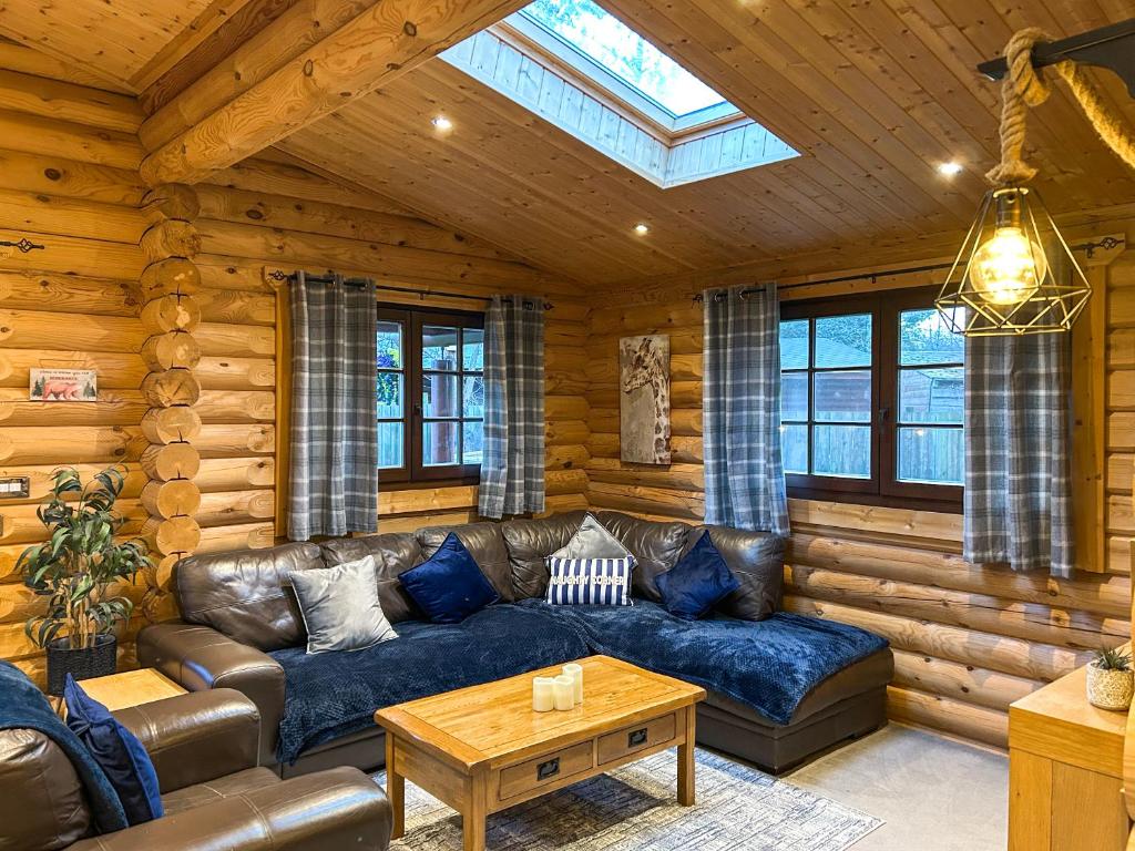 a living room with a leather couch in a log cabin at The Outback - Uk50982 in West Thirston