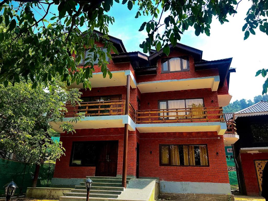a red brick building with stairs in front of it at The Walnut House in Pahalgām