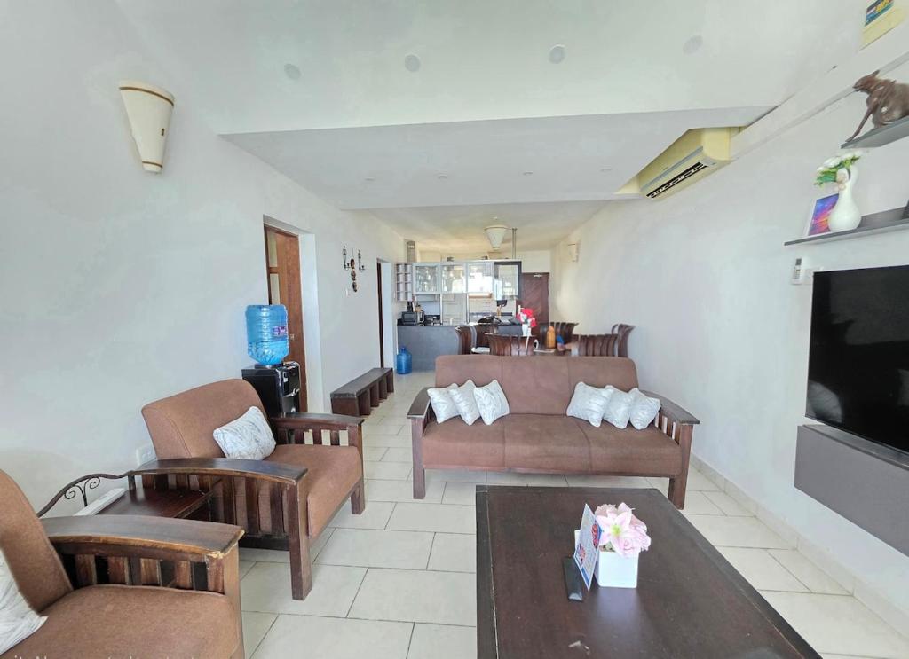 a living room with couches and a tv at Chic two bedroom Beachfront apartment 5th floor in Ukunda