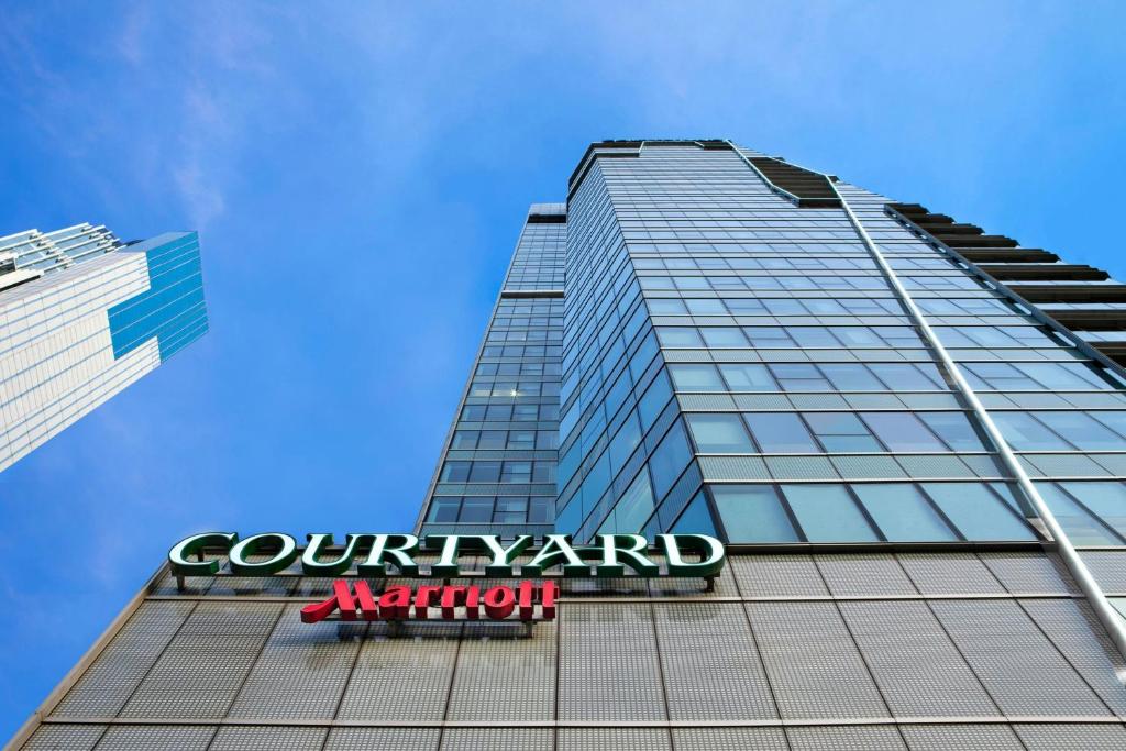 a tall building with a sign in front of it at Courtyard by Marriott Hong Kong in Hong Kong