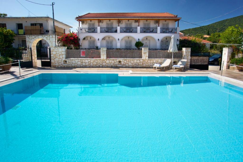 a large blue swimming pool in front of a building at Diamanto Complex in Karavomylos