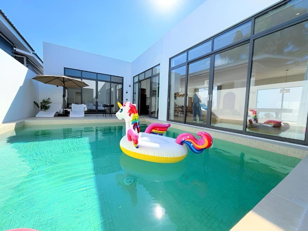 a swimming pool with an inflatable unicorn in a house at Quint Pool Villas in Jomtien Beach