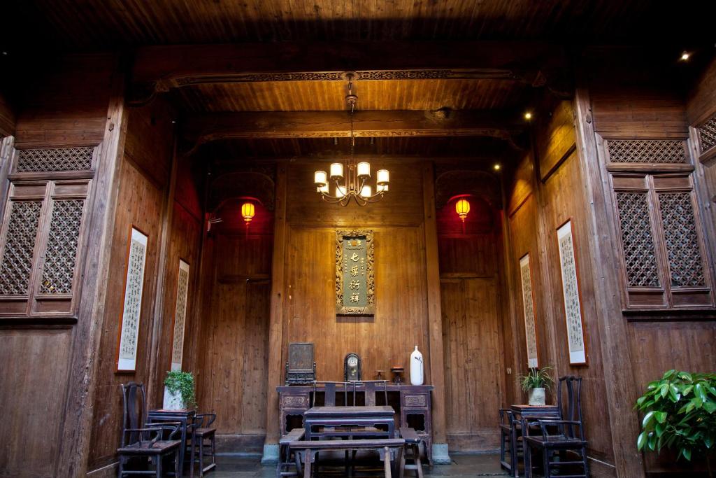 a dining room with tables and chairs and a chandelier at WuYuan QiYe YanXiang Guesthouse in Wuyuan