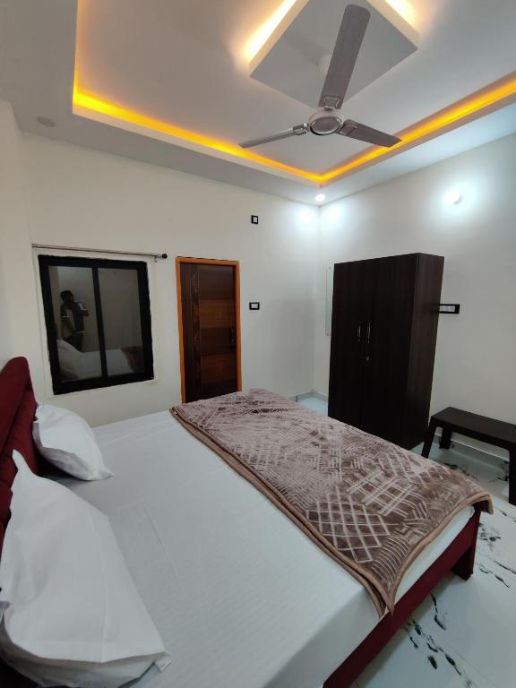 a bedroom with a bed with a ceiling fan at Hotel Ekana in Chhatarpur