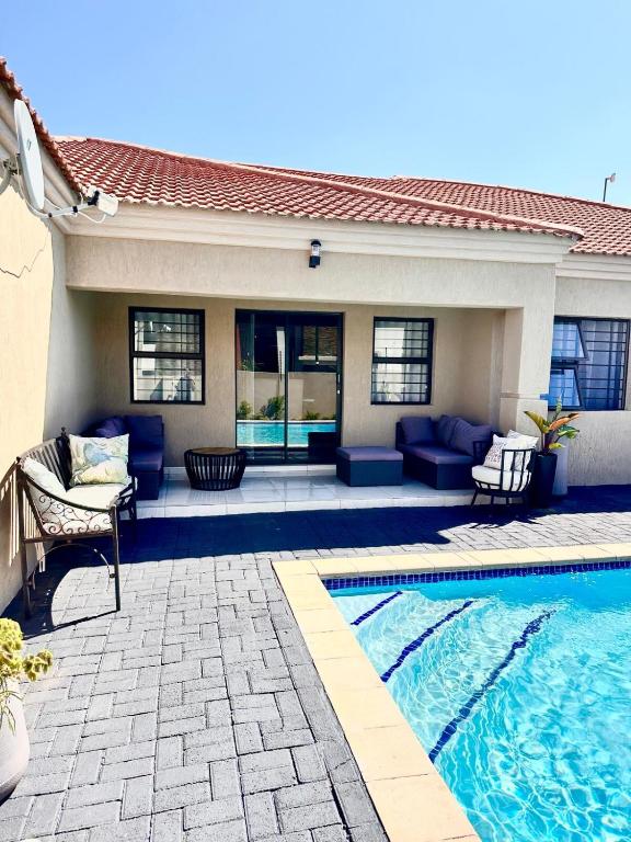a house with a swimming pool and a patio at Elle Residence in Gaborone