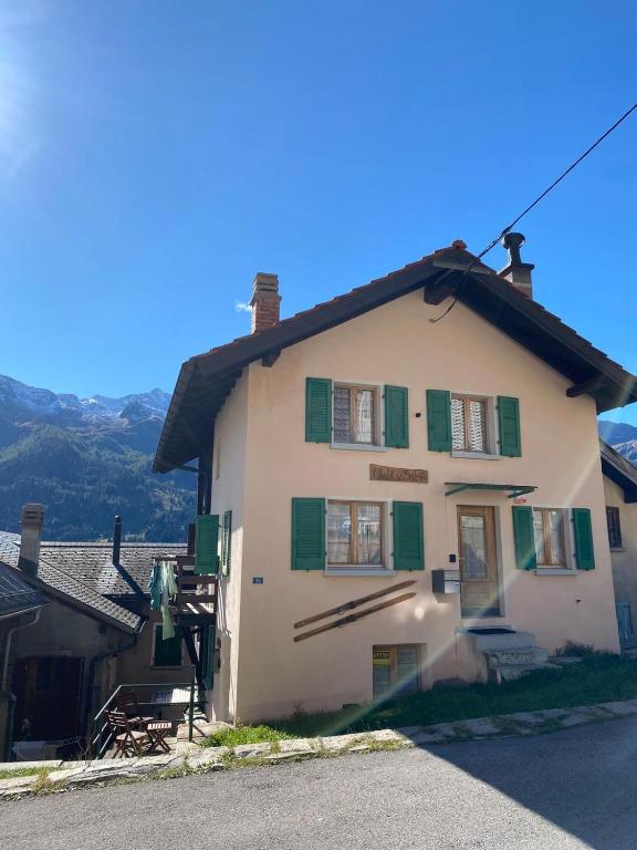 a large white building with green shutters on a street at Chalet del Sole in Quinto
