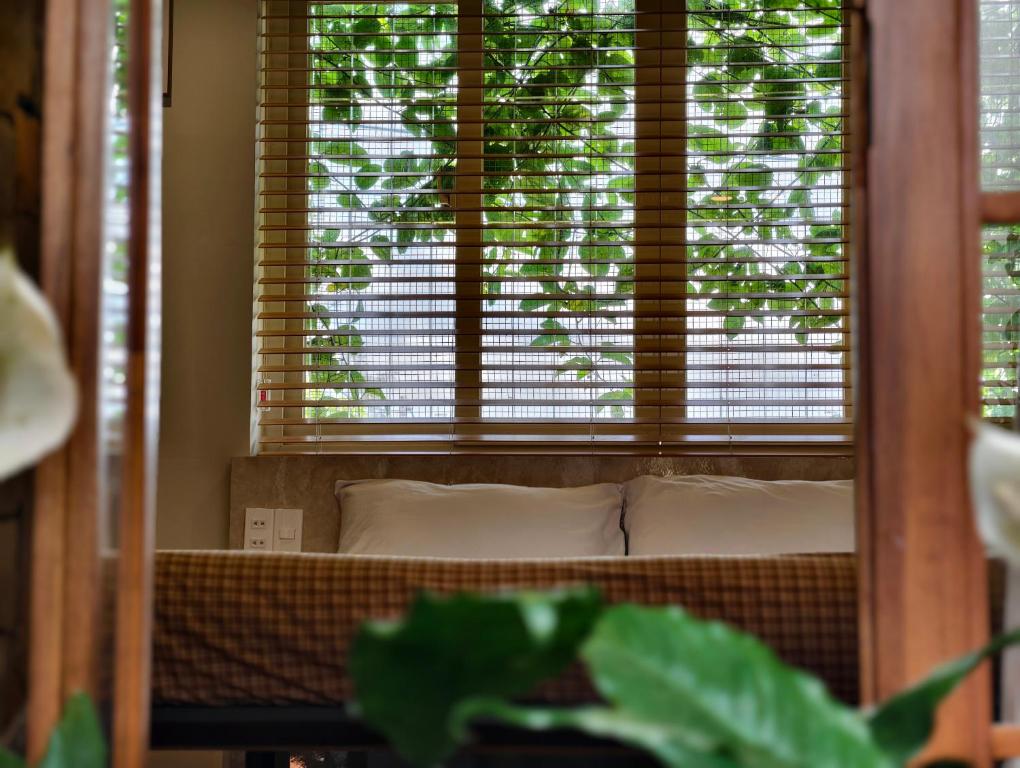 a window in a room with a bed and a plant at Ansora Homestay Huế in Thôn An Hòa