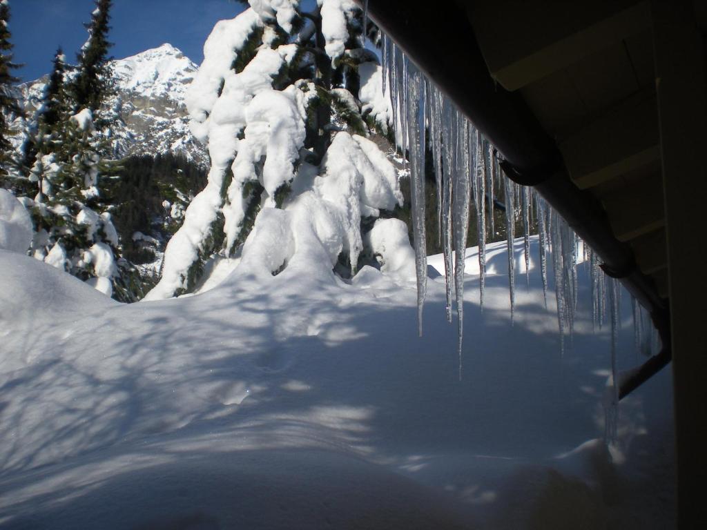 ein Bild von Eiszapfen, die von einem Haus im Schnee hängen in der Unterkunft Appartements Hexahüsle in Wald am Arlberg