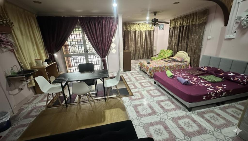 a living room with a bed and a table at Iltizam Guest House in Kuala Berang