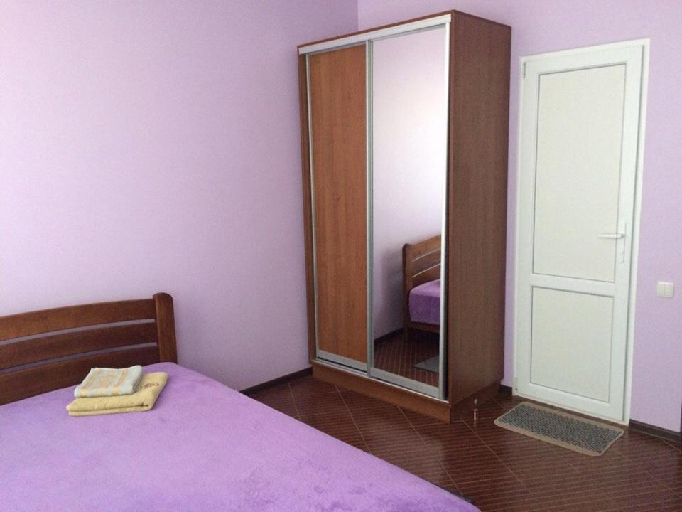 イズマイールにあるGuest House Na Suvorovaのベッドルーム(紫色のベッド1台、鏡付)