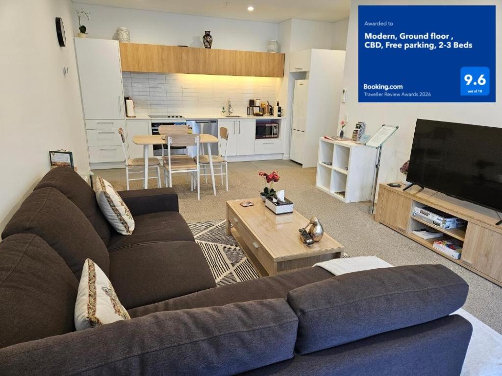 a living room with a couch and a tv at Modern, Ground floor , CBD, Free parking, 2-3 Beds in Christchurch