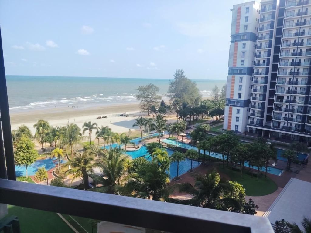 a view of the beach from the balcony of a resort at Timurbay Seafront By Moonlight Sea & Poolview in Kuantan