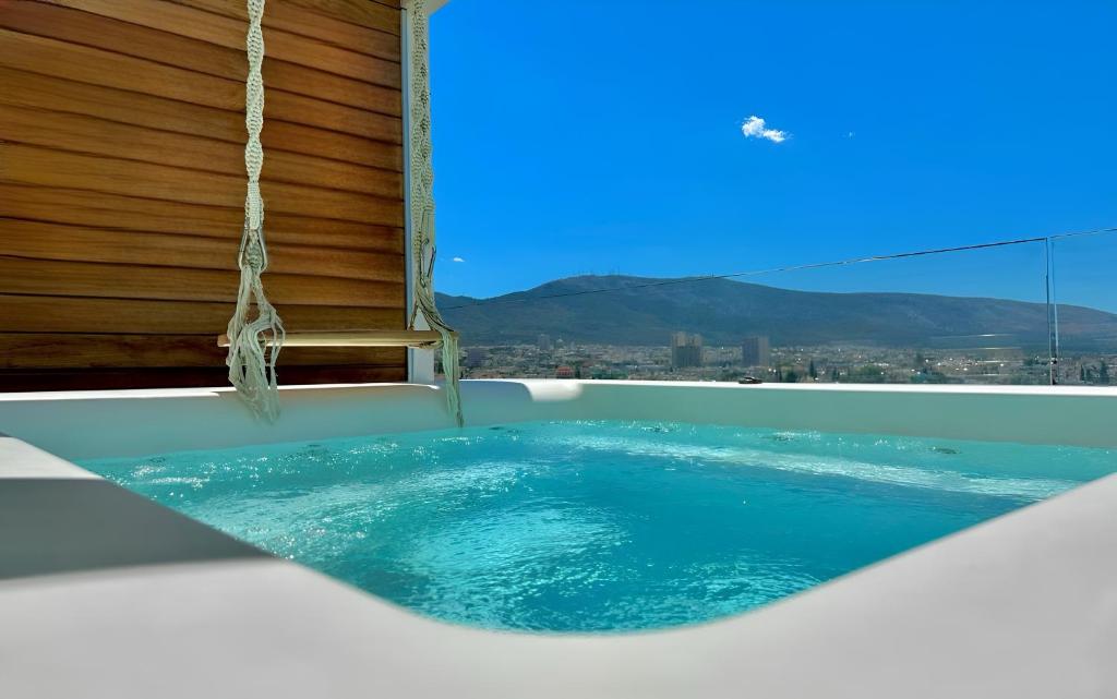 a jacuzzi tub with a view of the city at One 360 Skyline Athens Penthouses in Athens