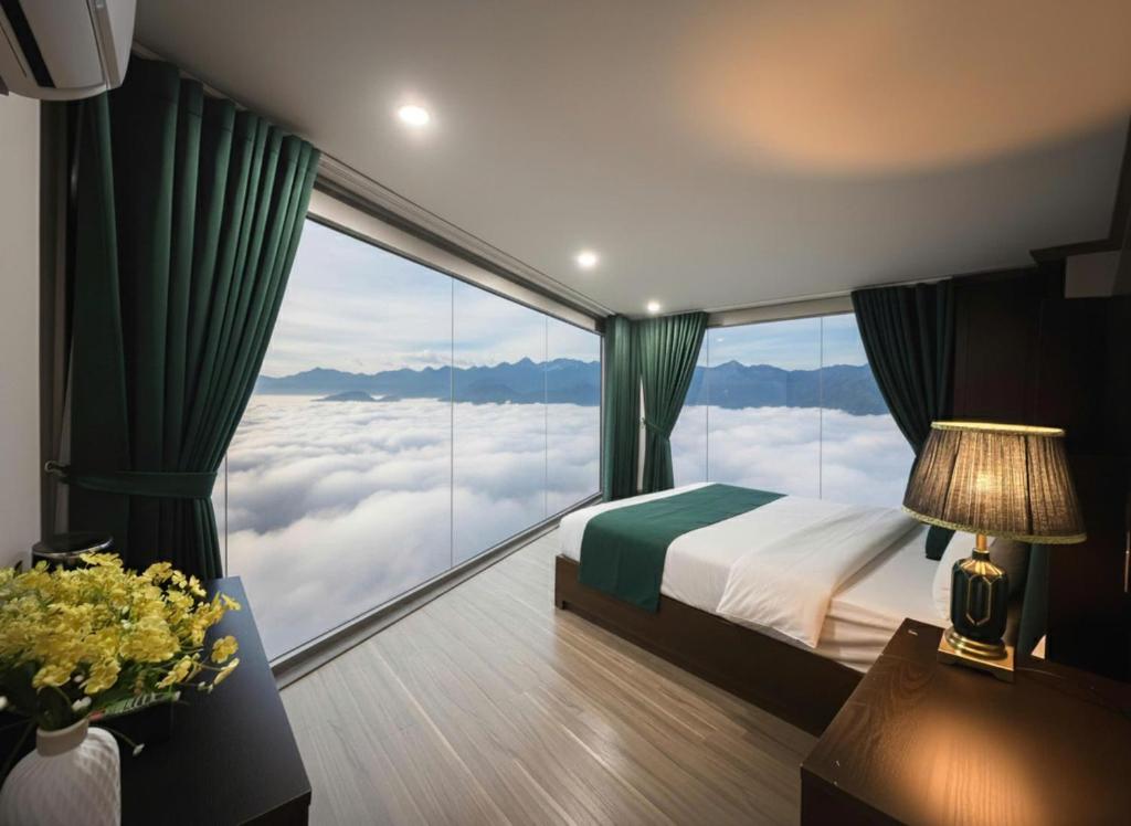 a bedroom with a bed and a large window at Cloud Chaser Hotel in Sapa