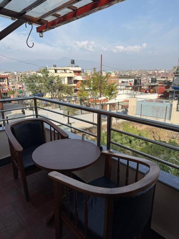 a table and chairs on a balcony with a view at Mi casa in Kathmandu