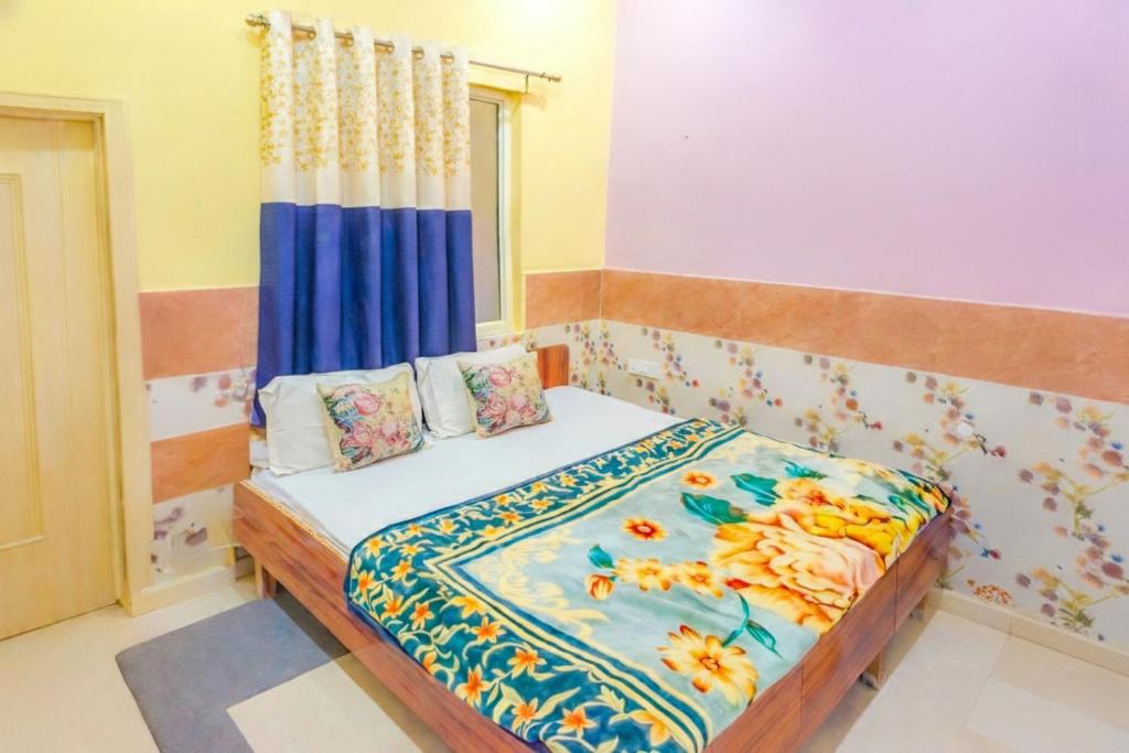 a bedroom with a bed with a blue curtain at Shree Ladli Ju Dham in Vrindāvan